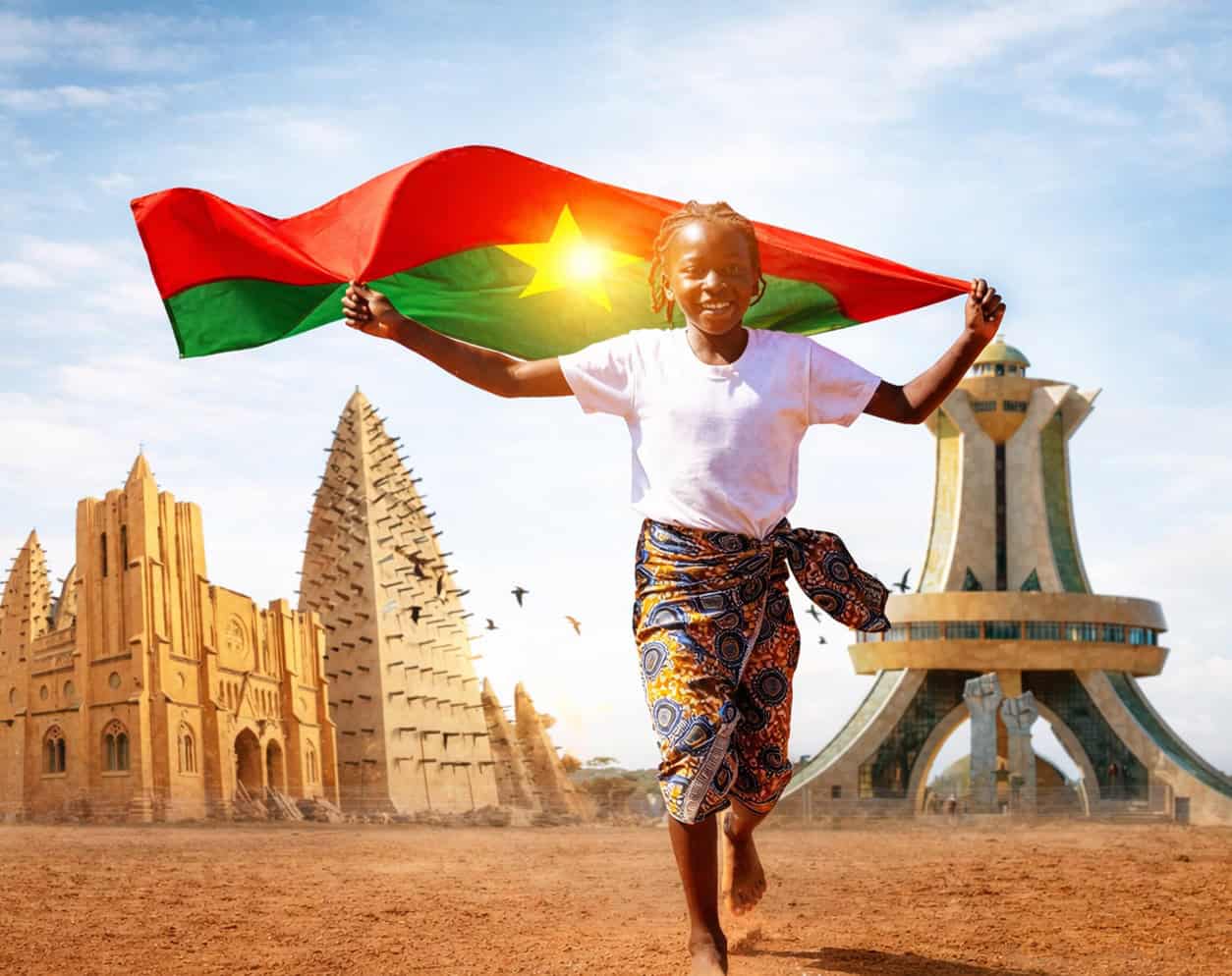 Jeune fille souriante tenant le drapeau du Burkina Faso.